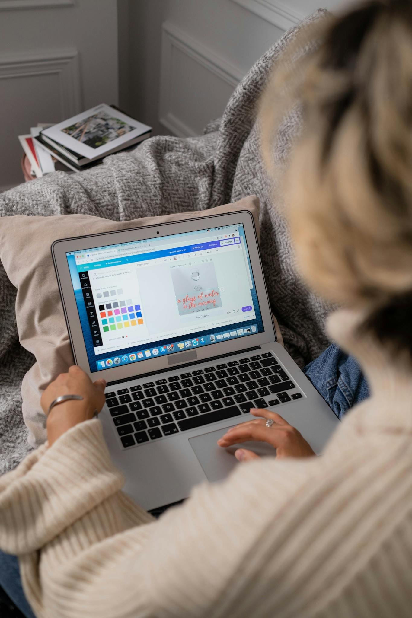 Woman working on design software from home on a comfortable couch.